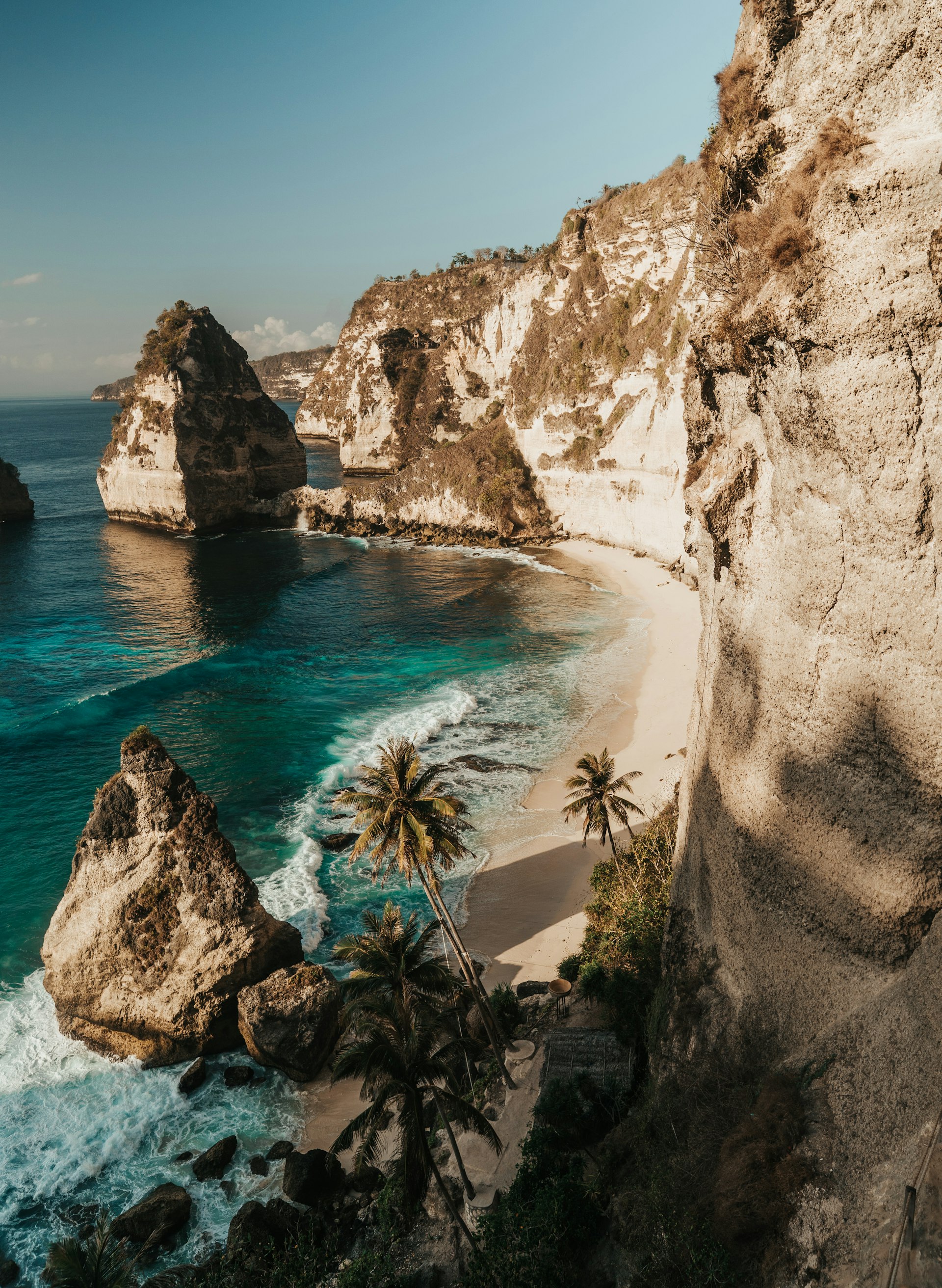 Golden sunset over a Balinese beach with silhouetted palm trees and gentle waves — the kind of evening you remember for years